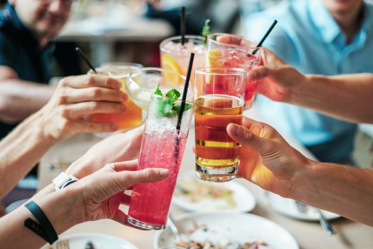 Unique Themed Cocktails Bars in London - Five drinks being held up between 5 hands