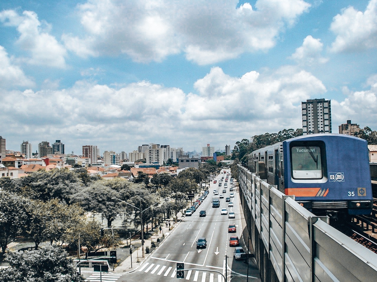Rio Carnival Subway - Image of train entering platform above a busy highway road