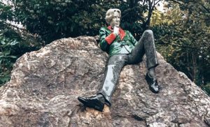 Statue of Oscar Wilde resting on a stone