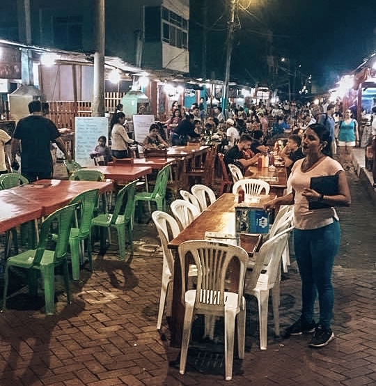 Busy street filled with dining tables