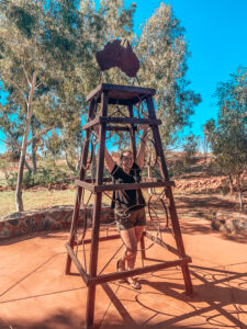 Erldunda Roadhouse - Sarah standing in the middle of Australia statue