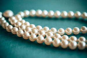 Broome pearl farm - Pearl necklace laying on a blue surface