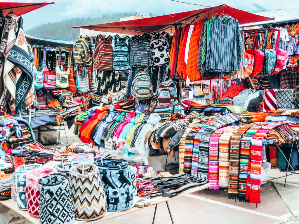 Otavalo Market - Stall selling colourful clothing and bags - Day Trips From Quito
