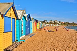 Brighton Beach Huts - Colourful beach huts next to yellow sand beach - Ultimate Guide To Melbourne