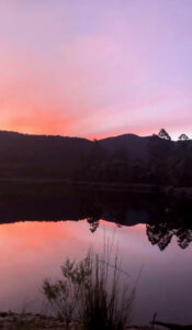 Lake Rosebery Foreshore Camp - Sunset over a lake with deep purple and pink hues in the sky - Lap of Tasmania